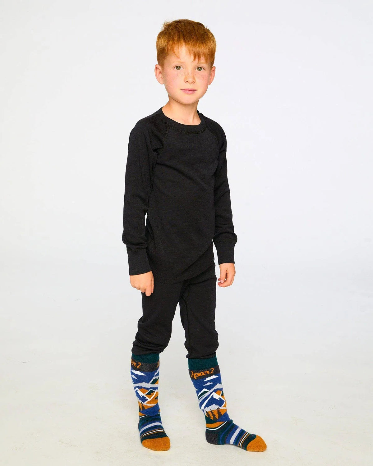 Child wearing the Black merino-blend base layer set, front view