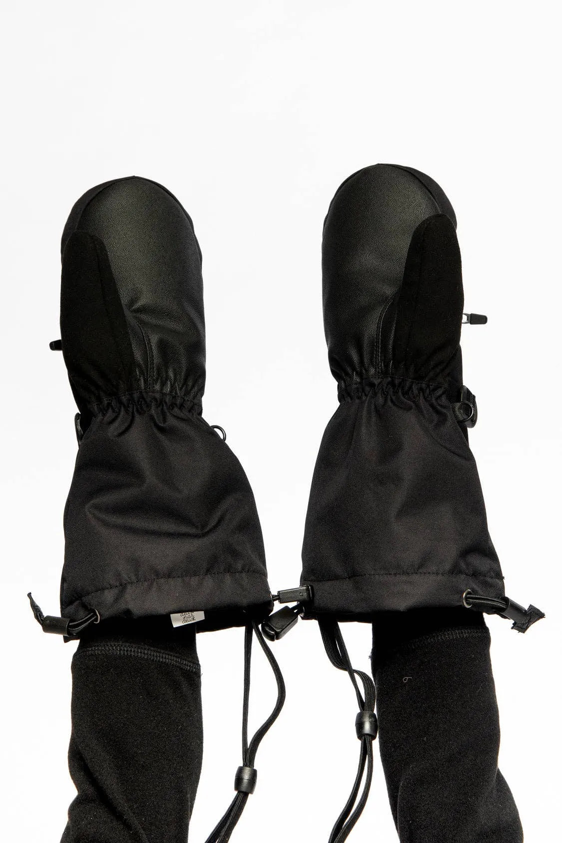 Palm side of both mittens worn, showing the grip palm, thumb panel and drawcord cuffs